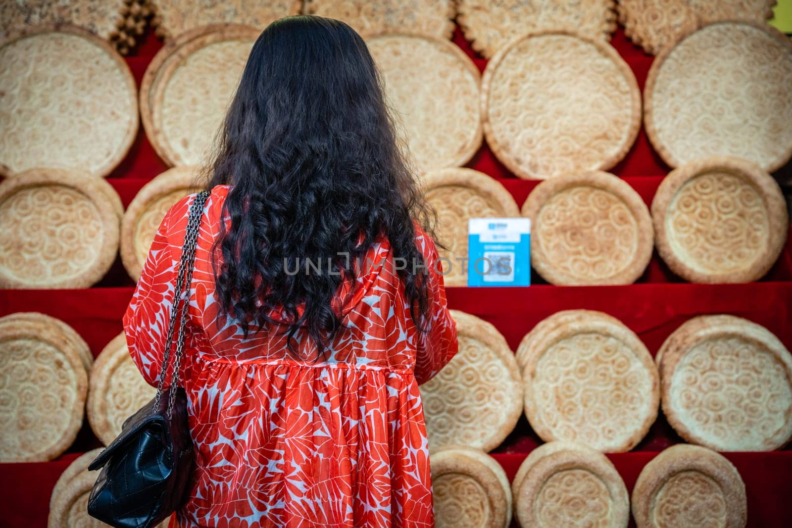 Xian, China -  July 2019 : Woman looking at the display with bread and bakery products on the street in the Muslim Quarter