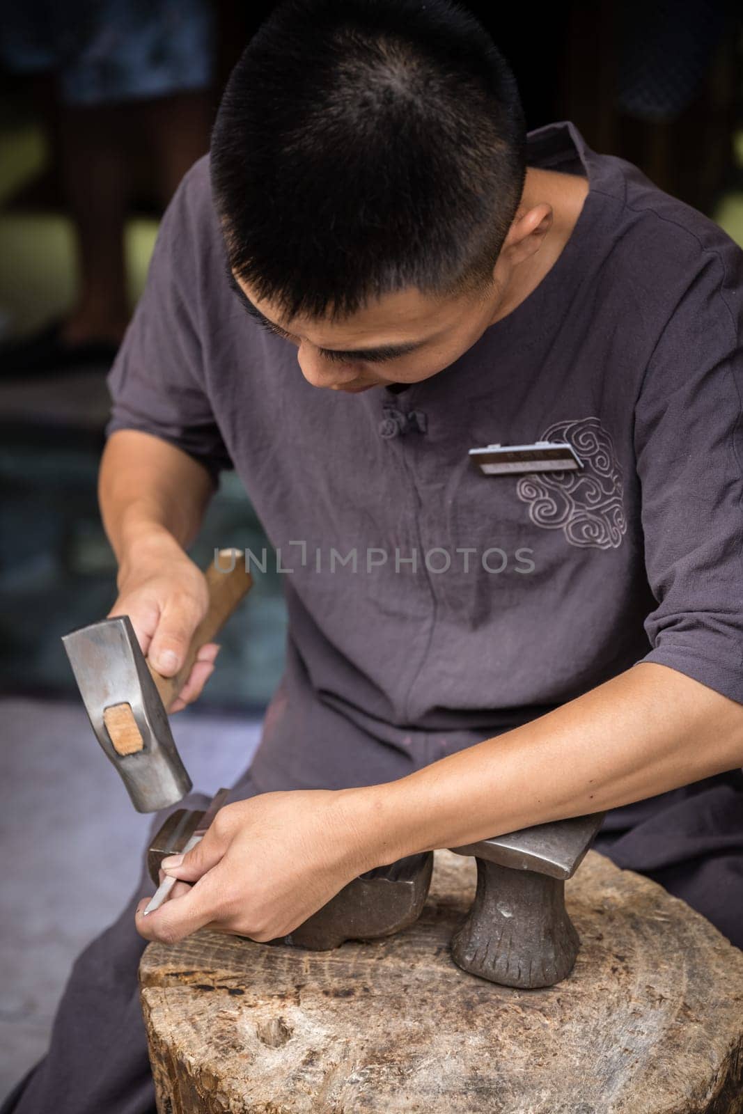 Xian, China -  July 2019 : Man using hammer to make crafts on the street market in the Muslim Quarter, Xian town, Shaanxi Province