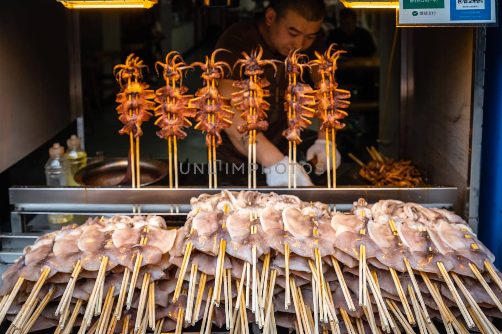 Xian, China -  July 2019 : Meat, snacks, calamari and fried baby octopus vendor selling food on the street in the Muslim Quarter
