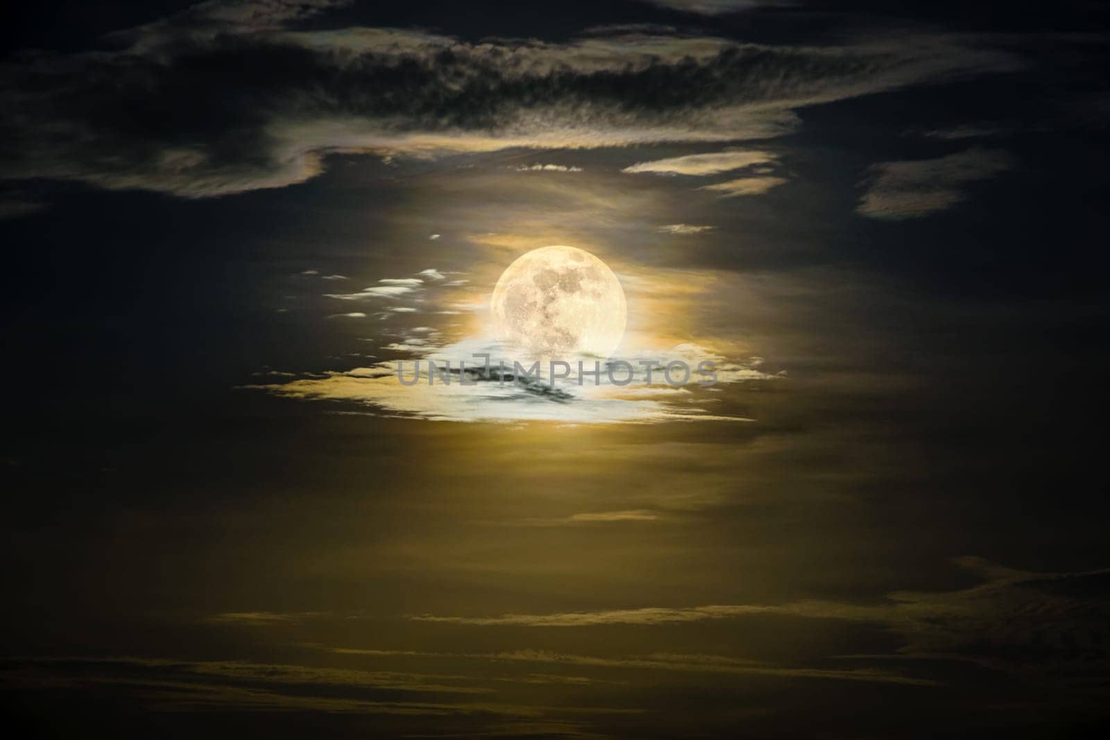 Super full moon on the yellow sky at midnight, golden moonlight reflect the cloud, Beautiful nature landscape view at night scene for background
