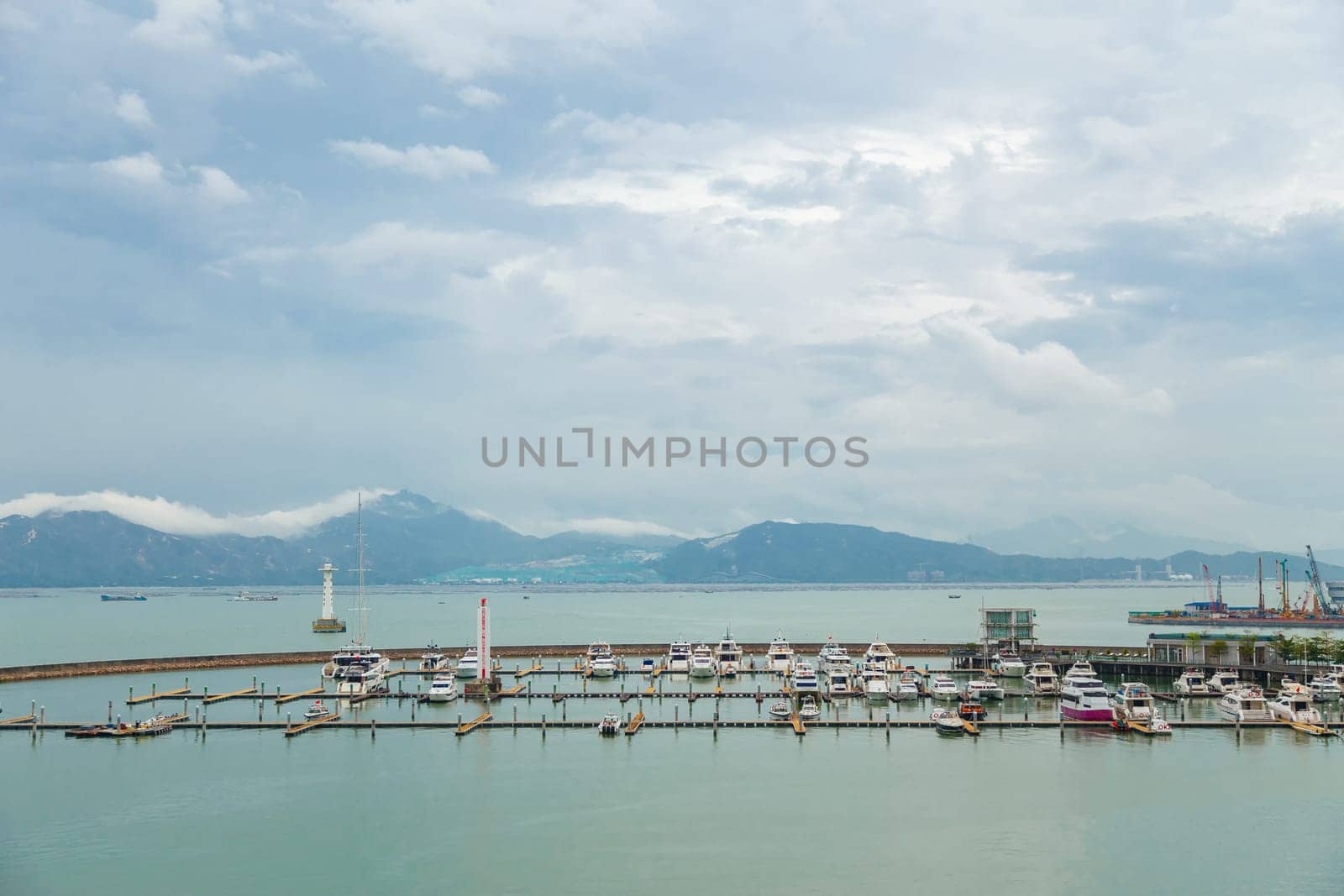 View of the bay with fishing boats and mountains away in cloudy weather, Shenzhen, China, Asia