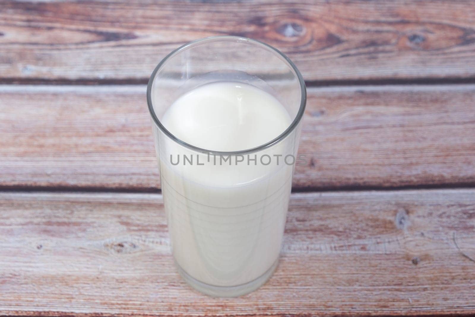 glass of milk on wooden background from above