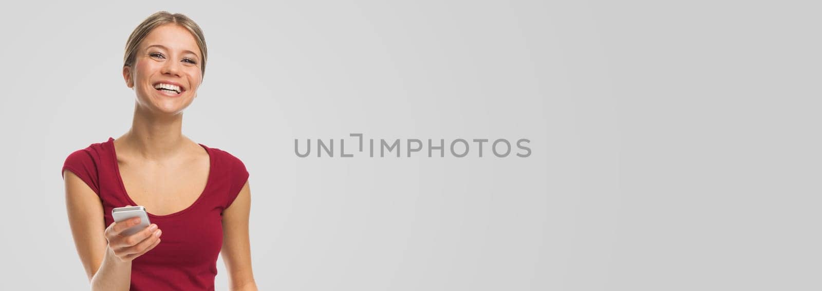 Smiling woman with her smartphone, on white