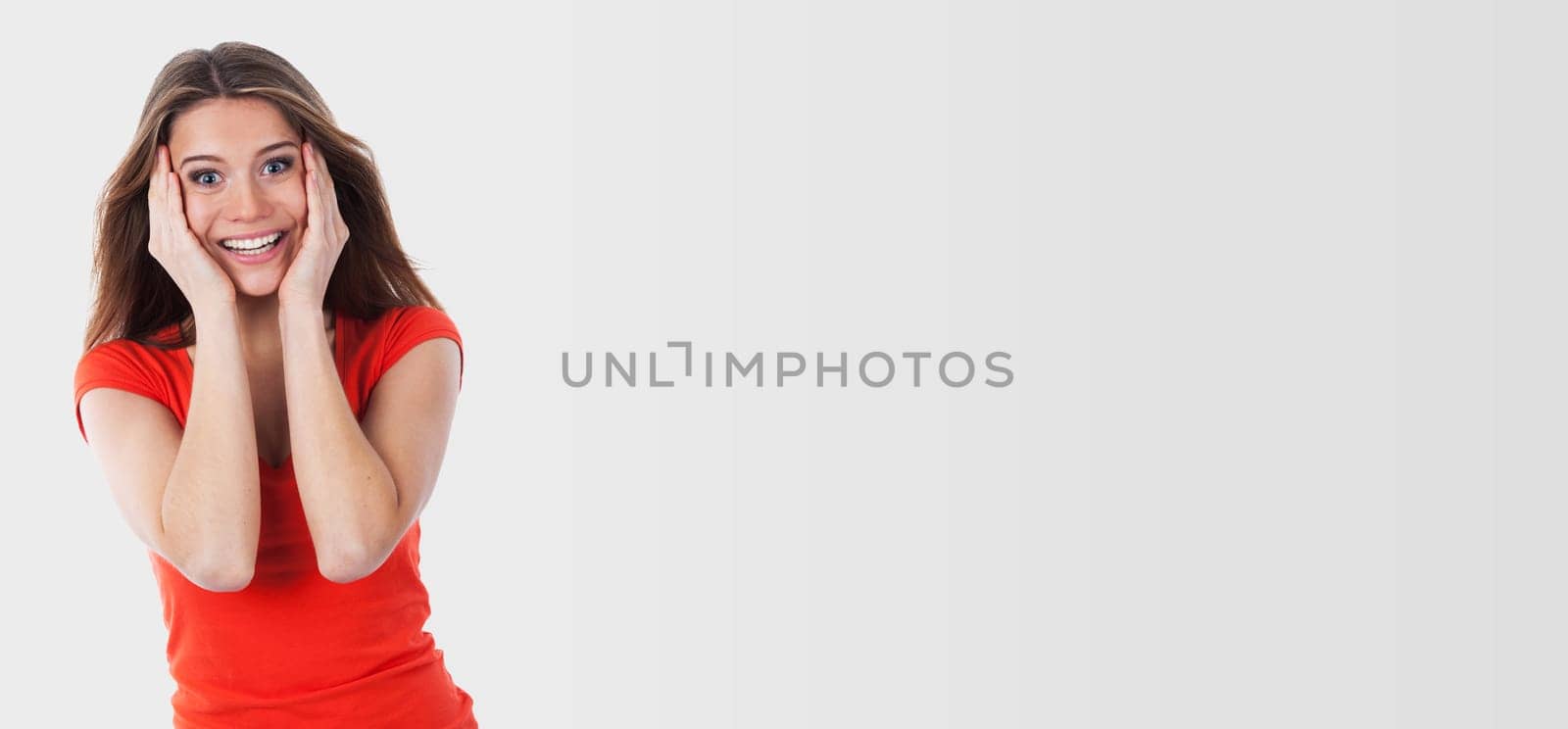 Young woman astonished and holding her face with her hands, isolated on white