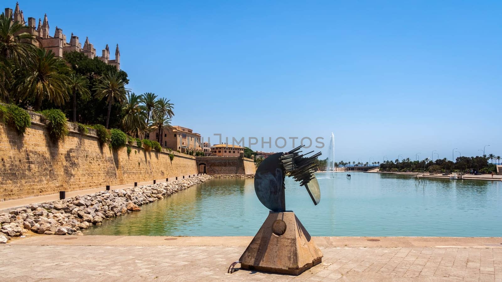 Palma, Mallorca, Spain, June 2015 An abstract sculpture in front of The Cathedral of Santa Maria of Palma in Mallorca with fountain and pond in front
