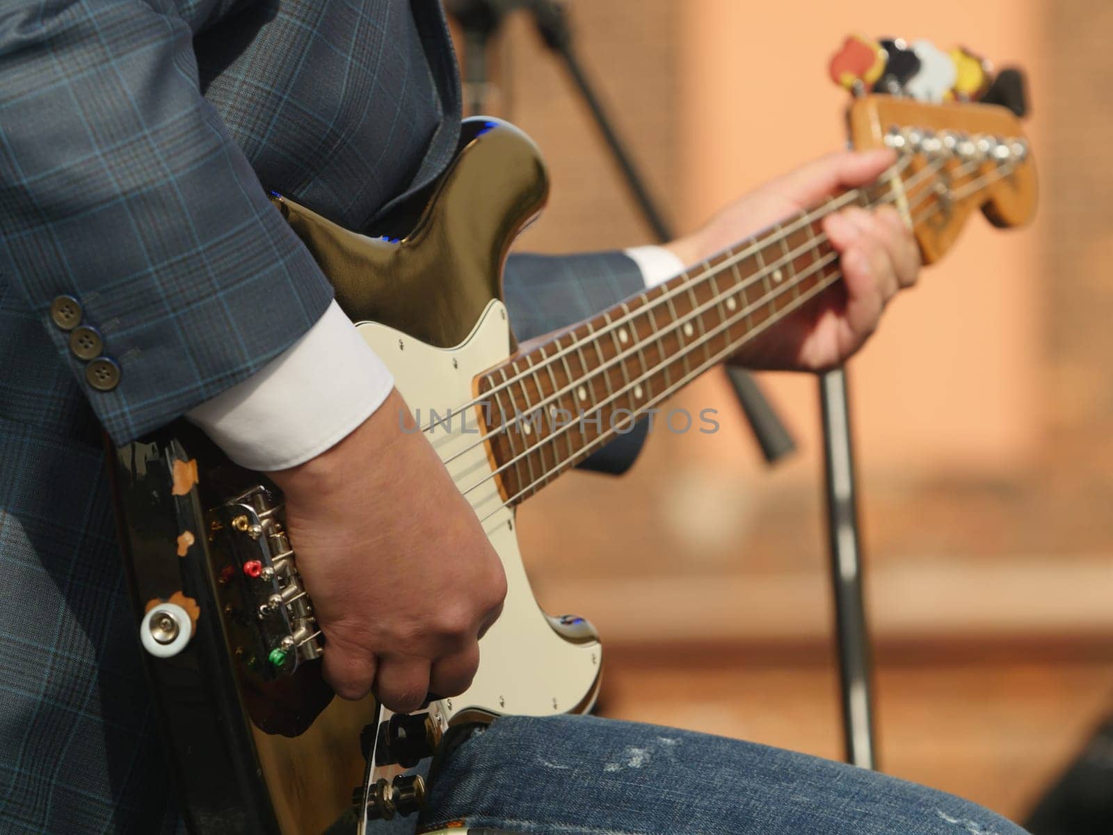 music, hand musician playing bass guitar close-up