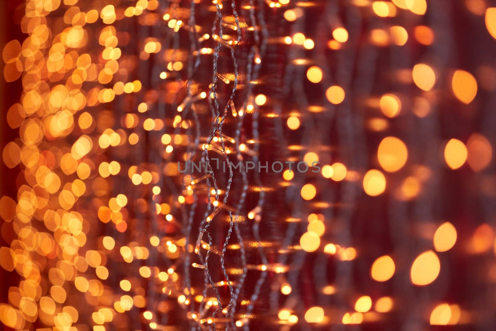 Festive background with LED lights garland. Christmas and New Year background. Blurred bokeh from the lights of a garland.