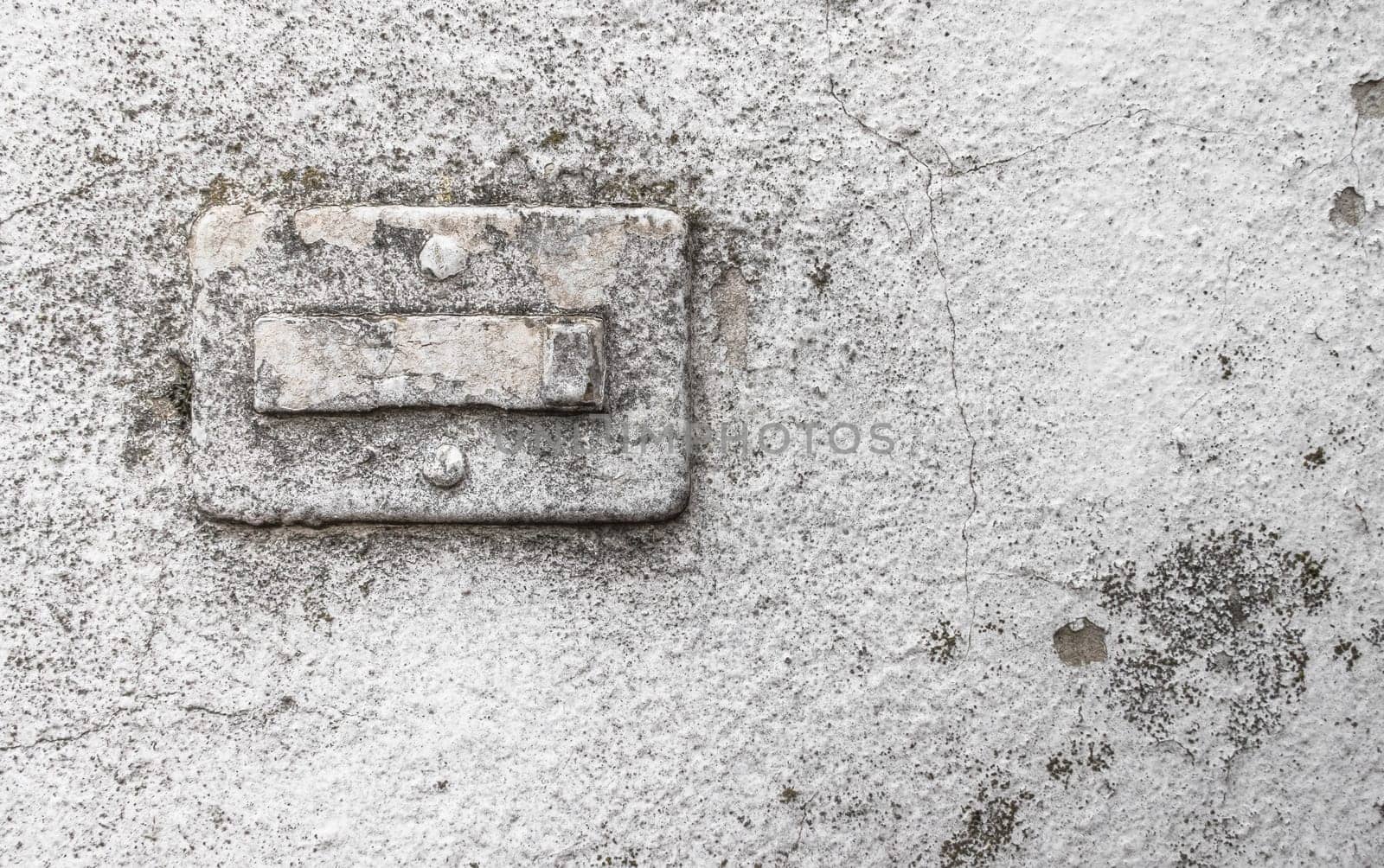 Broken doorbell, covered in paint, on a grungy wall with cracks and molds. Ideal for creative backgrounds.