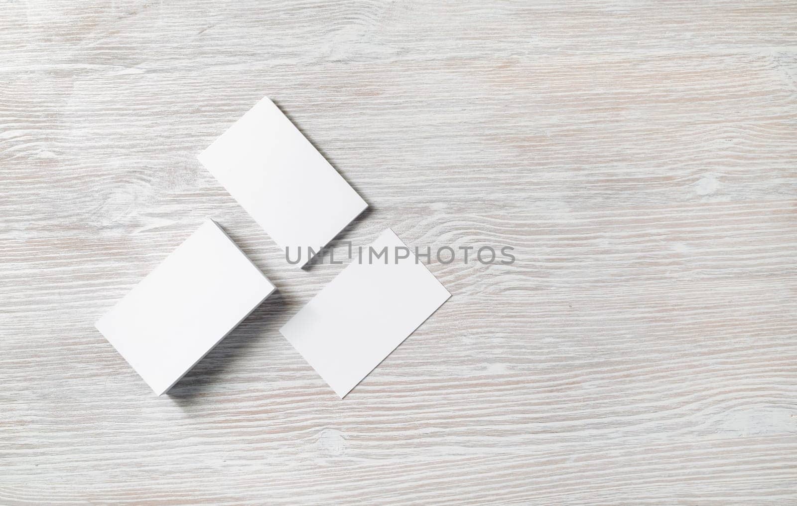 Photo of blank business cards on light wooden background. Template for ID. Copy space for text. Flat lay.