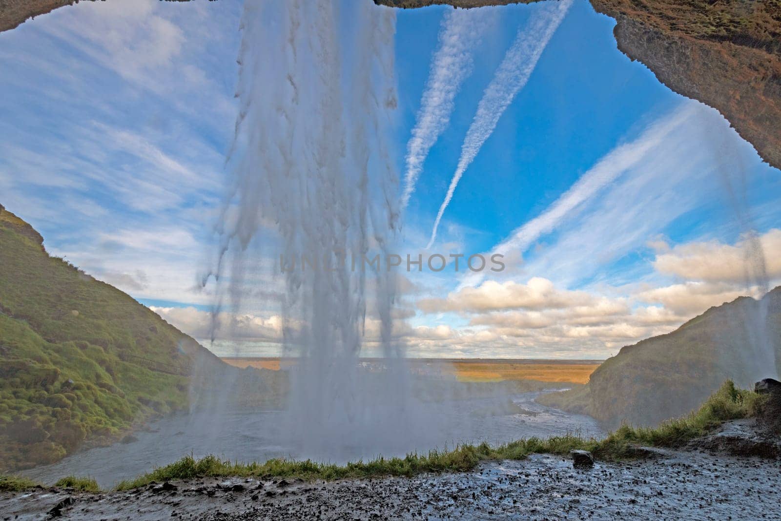 Looking at Blue Skies from Behind the Seljalandsfoss Waterfall in Iceland