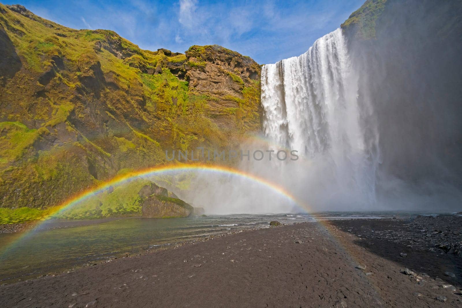 Full Rainbow in the Mist of Colorful Skogafoss Waterfall in Iceland