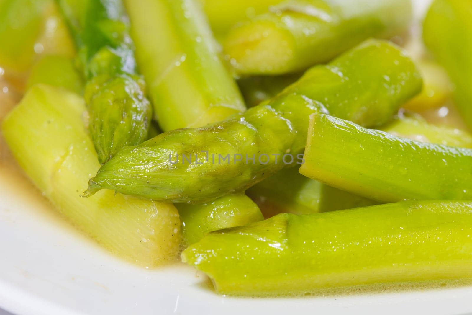 stir-fried asparagus in plate on wooden table