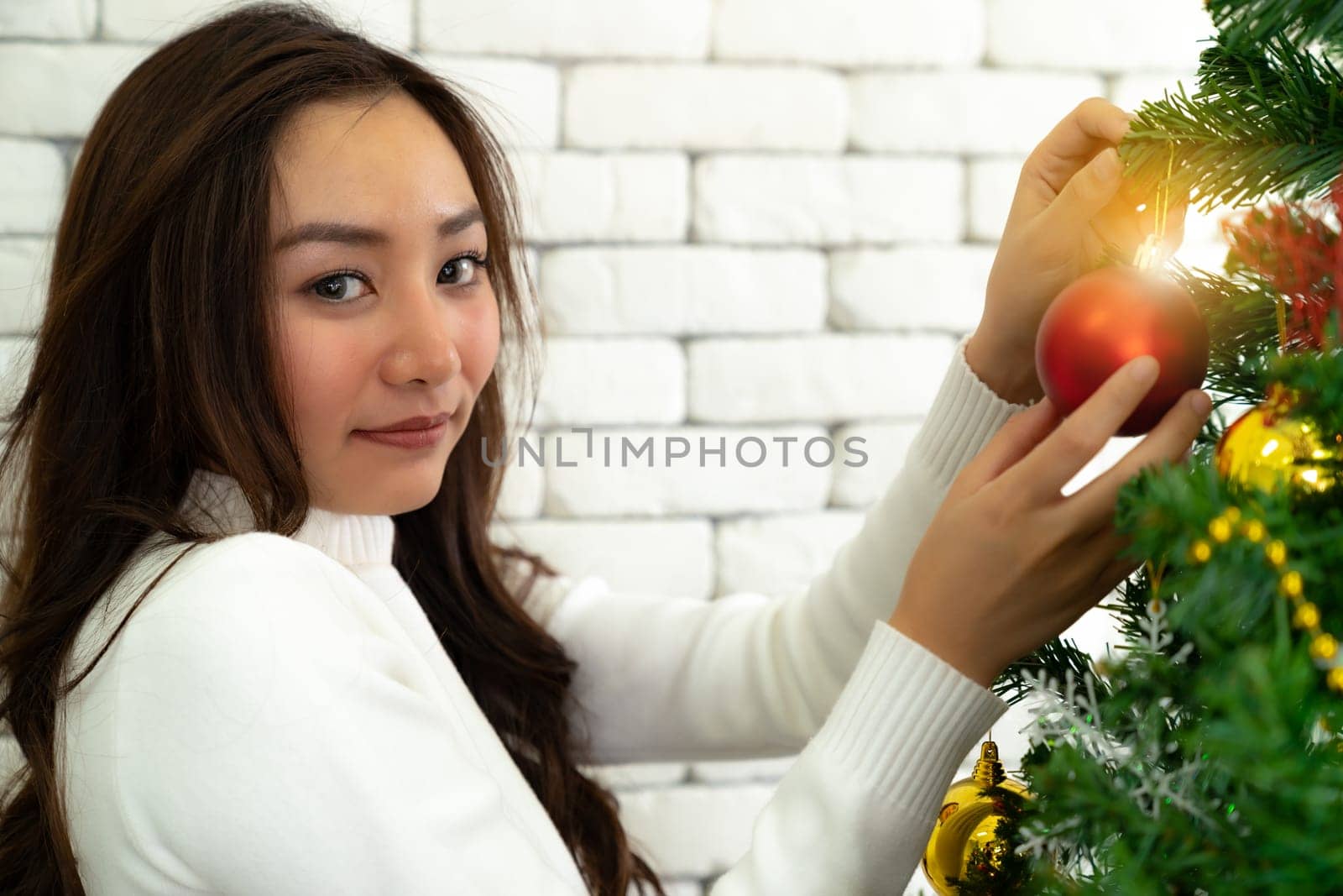 Young Teenager asian girl decorating Christmas tree prepare for Christmas party holiday with her boyfriend