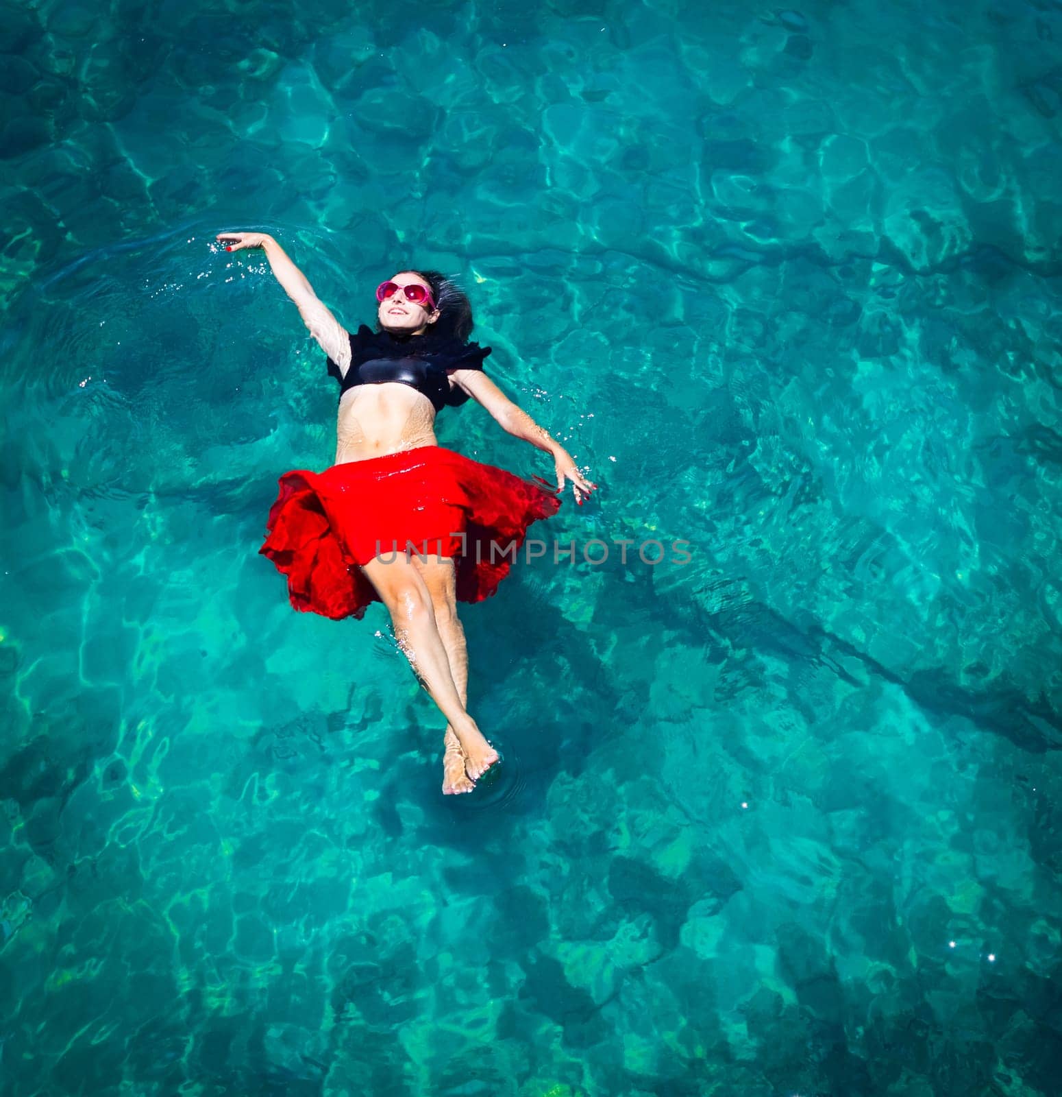 Aerial view of a beautiful woman dancing  in the sea