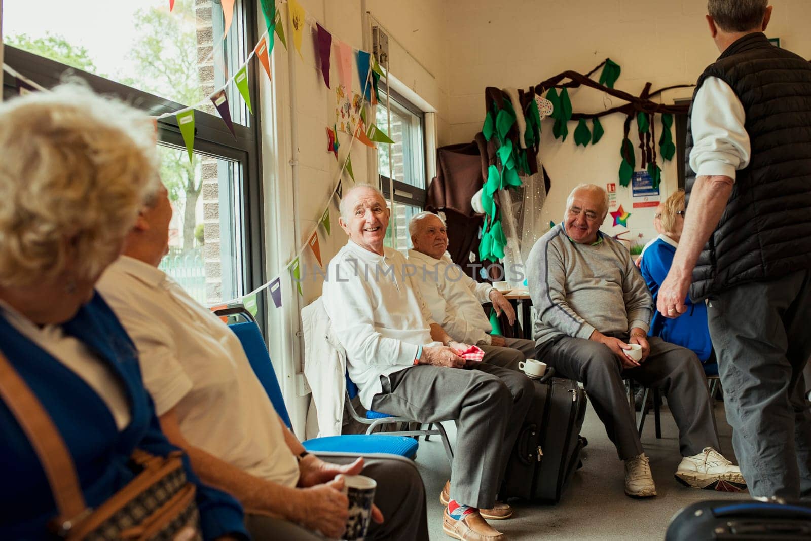 A group of senior adults sitting indoors and bonding with each other.
