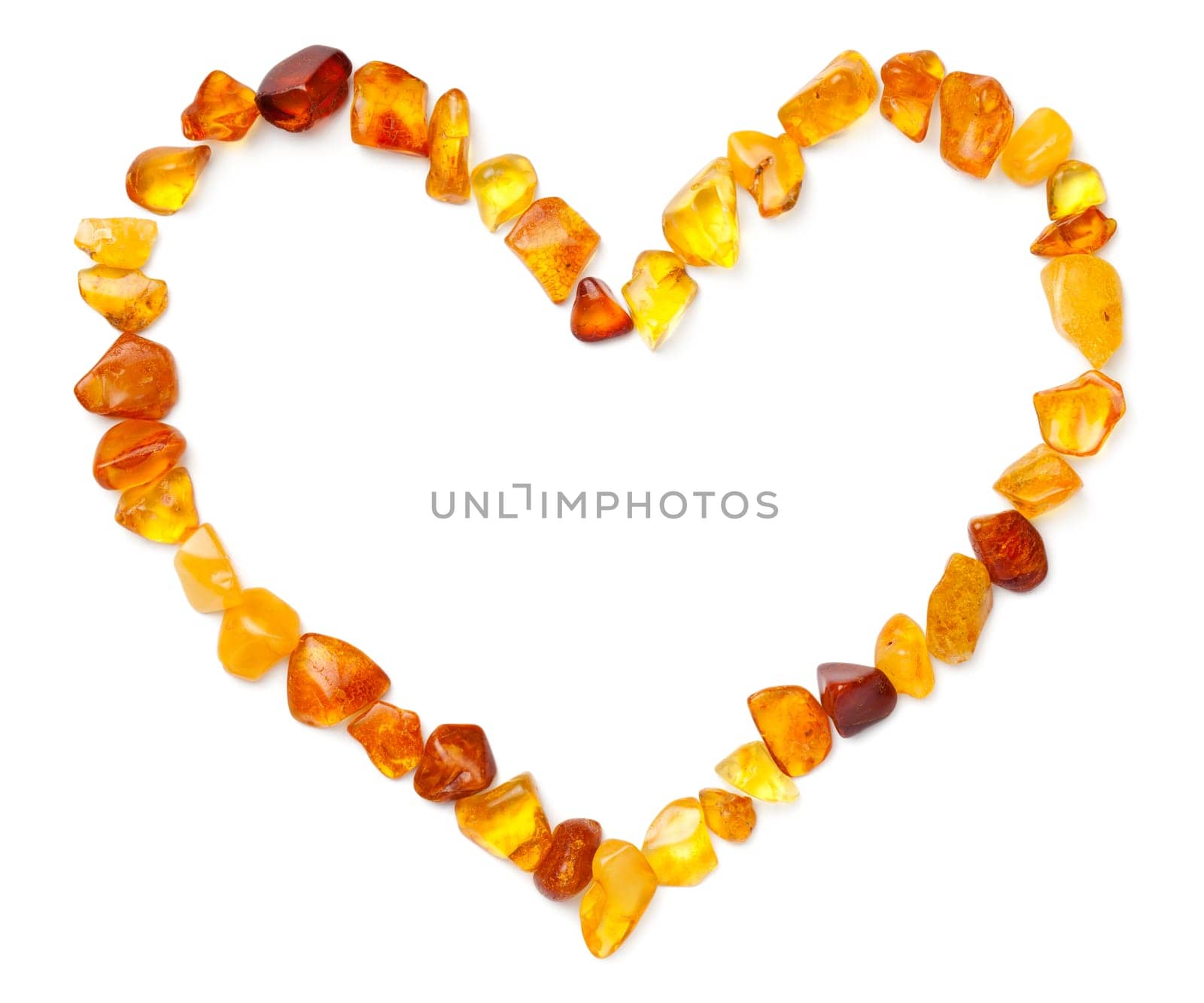 Heart shape made of amber isolated on white background. Polished ambers. Top view, flat lay