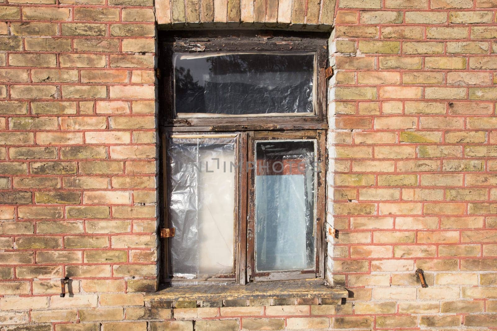 old broken closed window on the brick wall