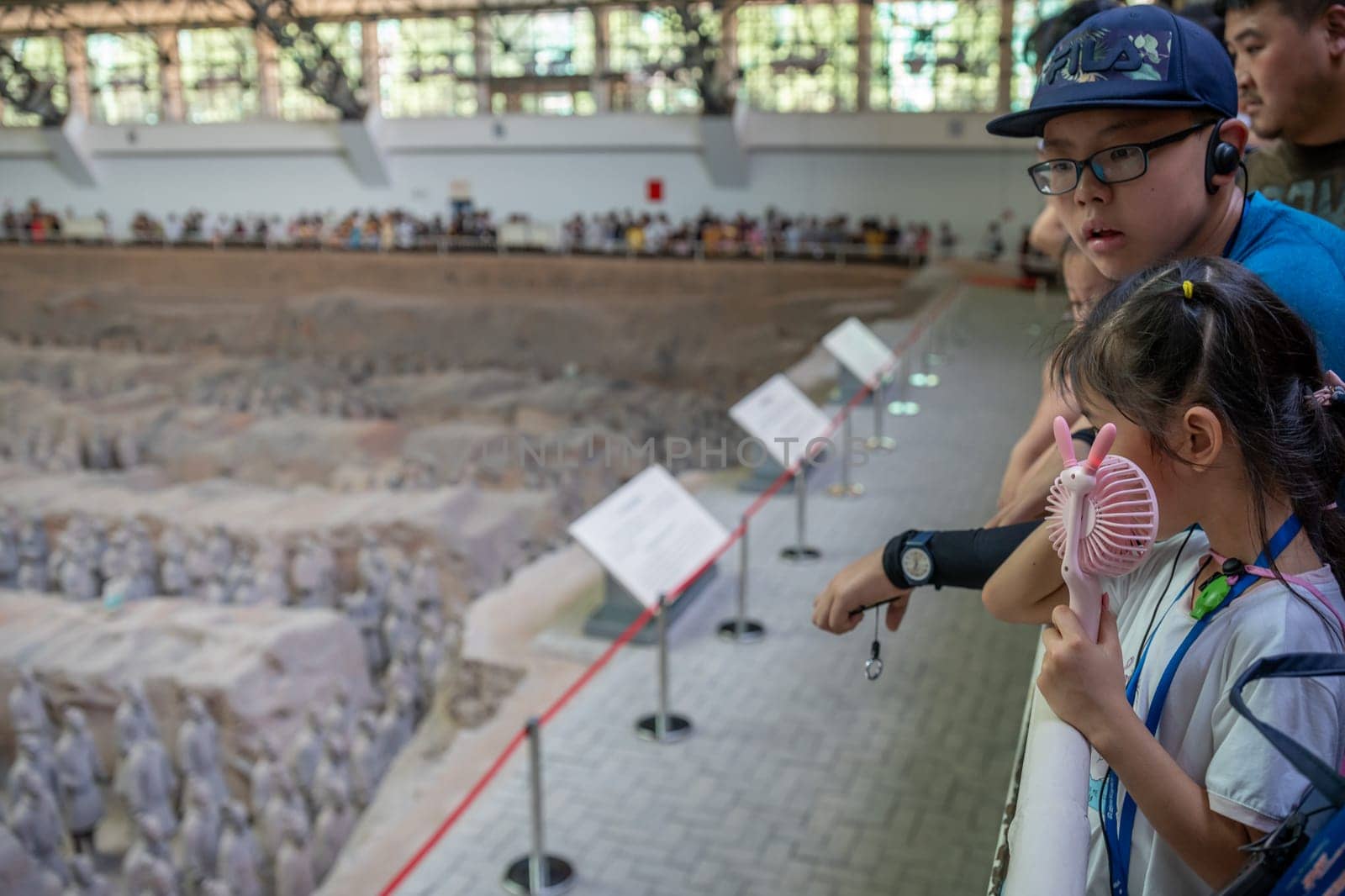 Xian, China -  July 2019 : Young chinese children tourist on the viewing platform admiring the Terracota Army, Xian, Shaanxi Province