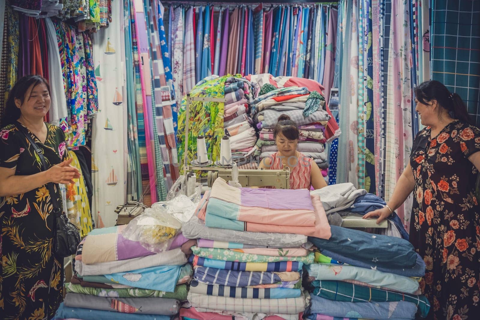 Chengdu, China -  July 2019 : Chinese woman standing in front of the small textile and tailoring shop