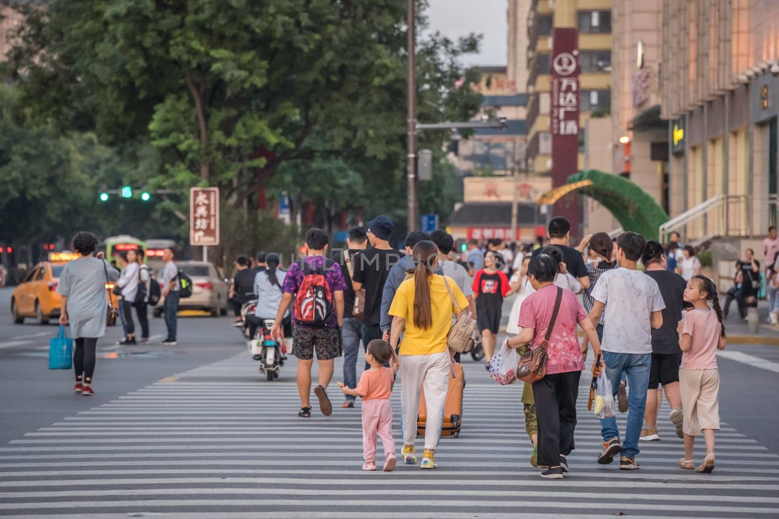 Xian, China -  August 2019 : People on a zebra crossing in the city of Xian in summer, Shaanxi Province
