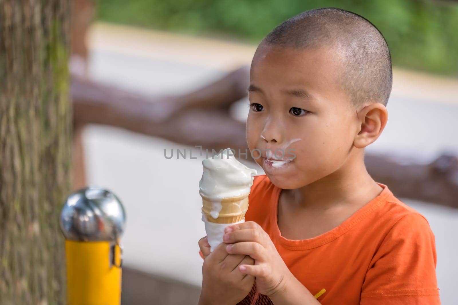 Zhangjiajie, China - August 2019 : Portrait of a young chinese boy devouring a large ice cream