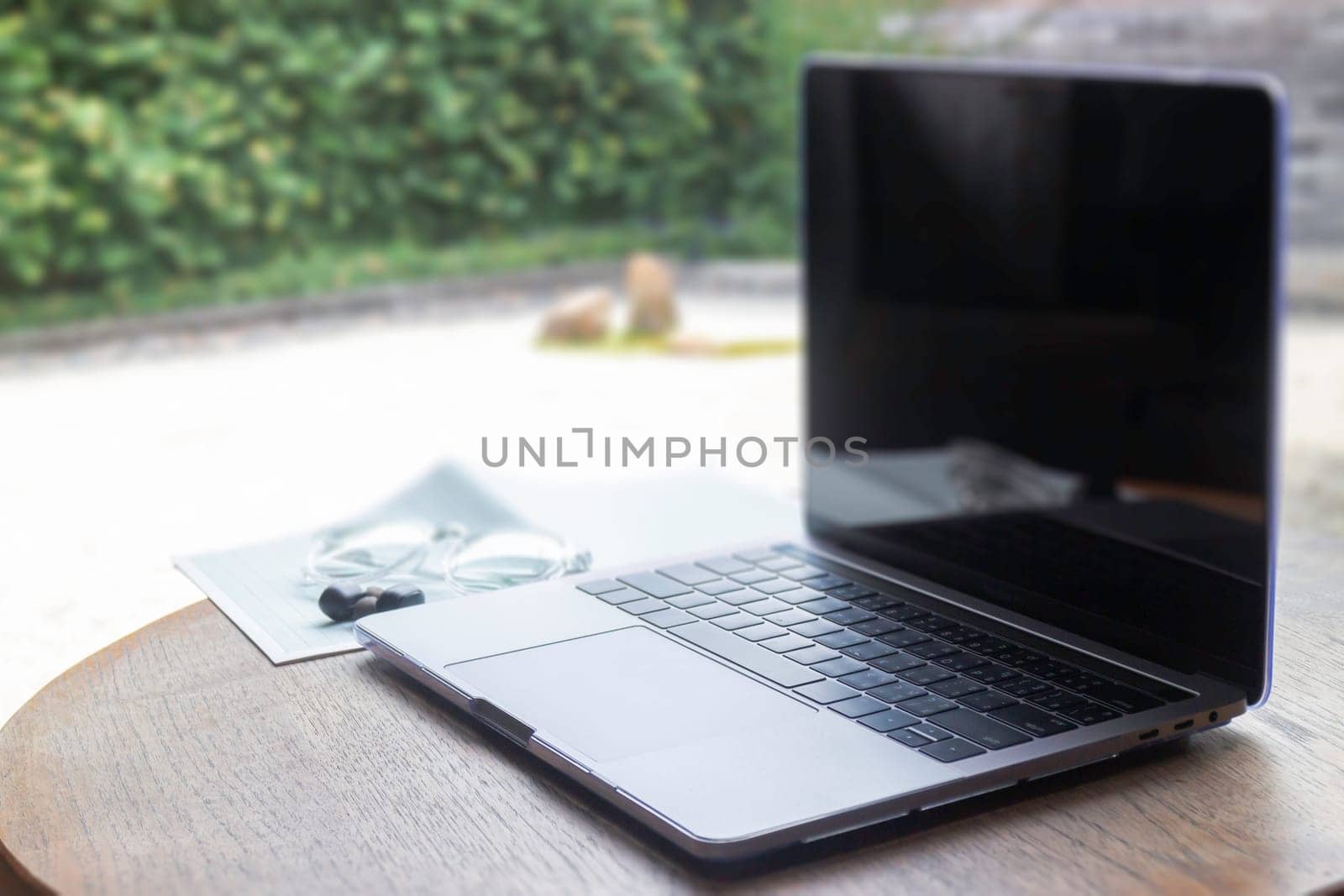 Modern laptop computer on wooden table in home garden, stock photo