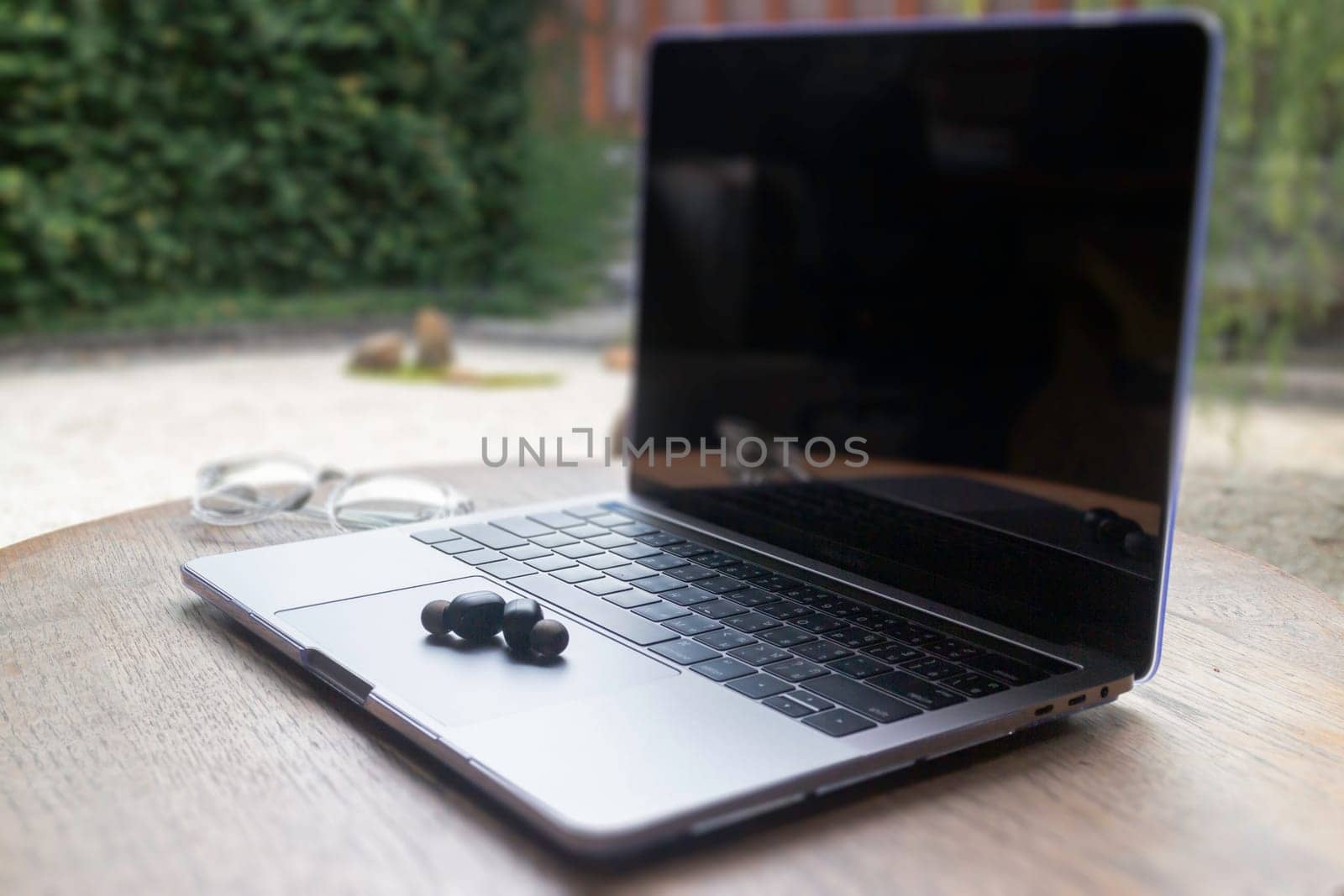 Modern laptop computer on wooden table in home garden, stock photo