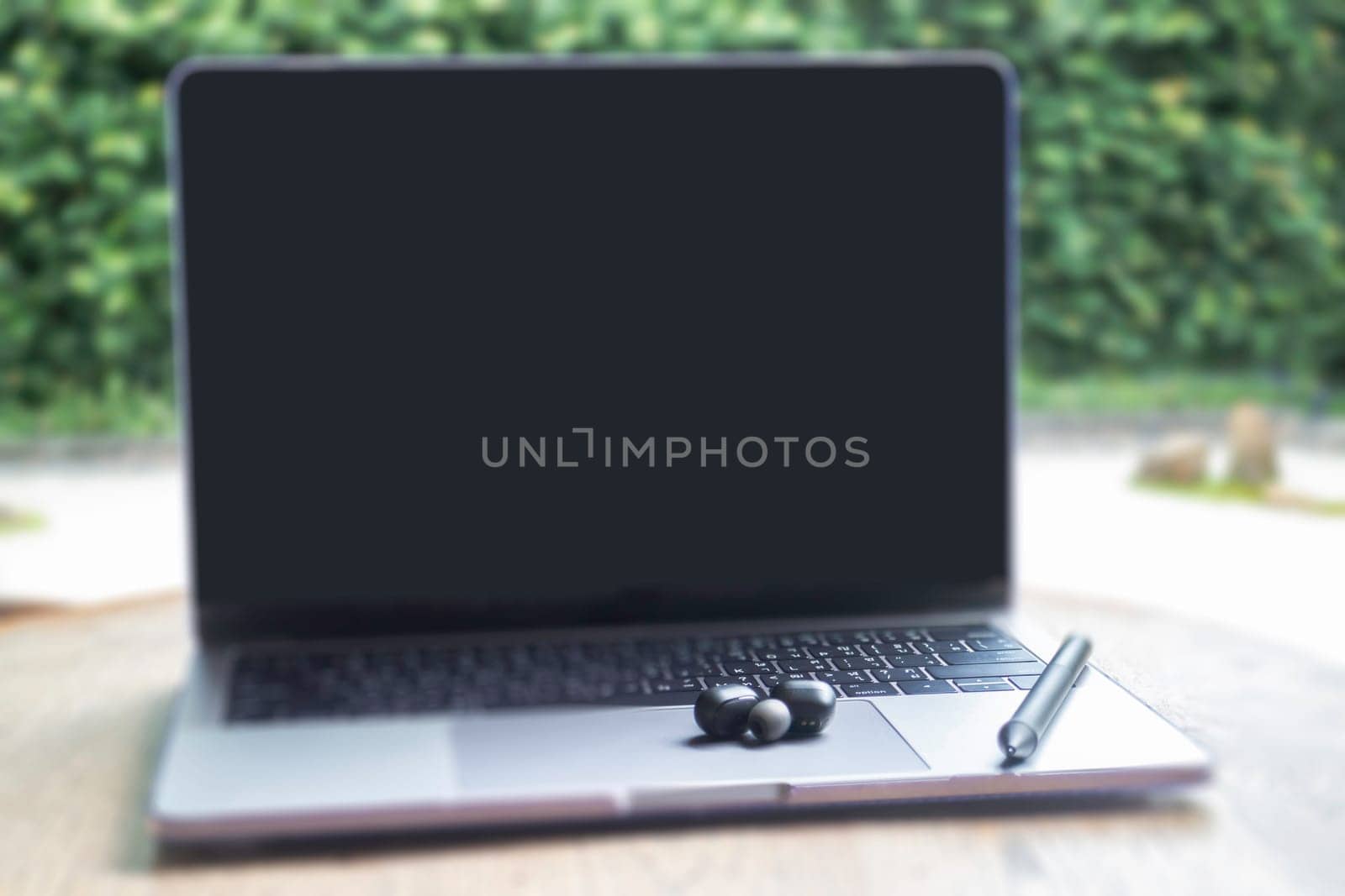 Modern laptop computer on wooden table in home garden, stock photo