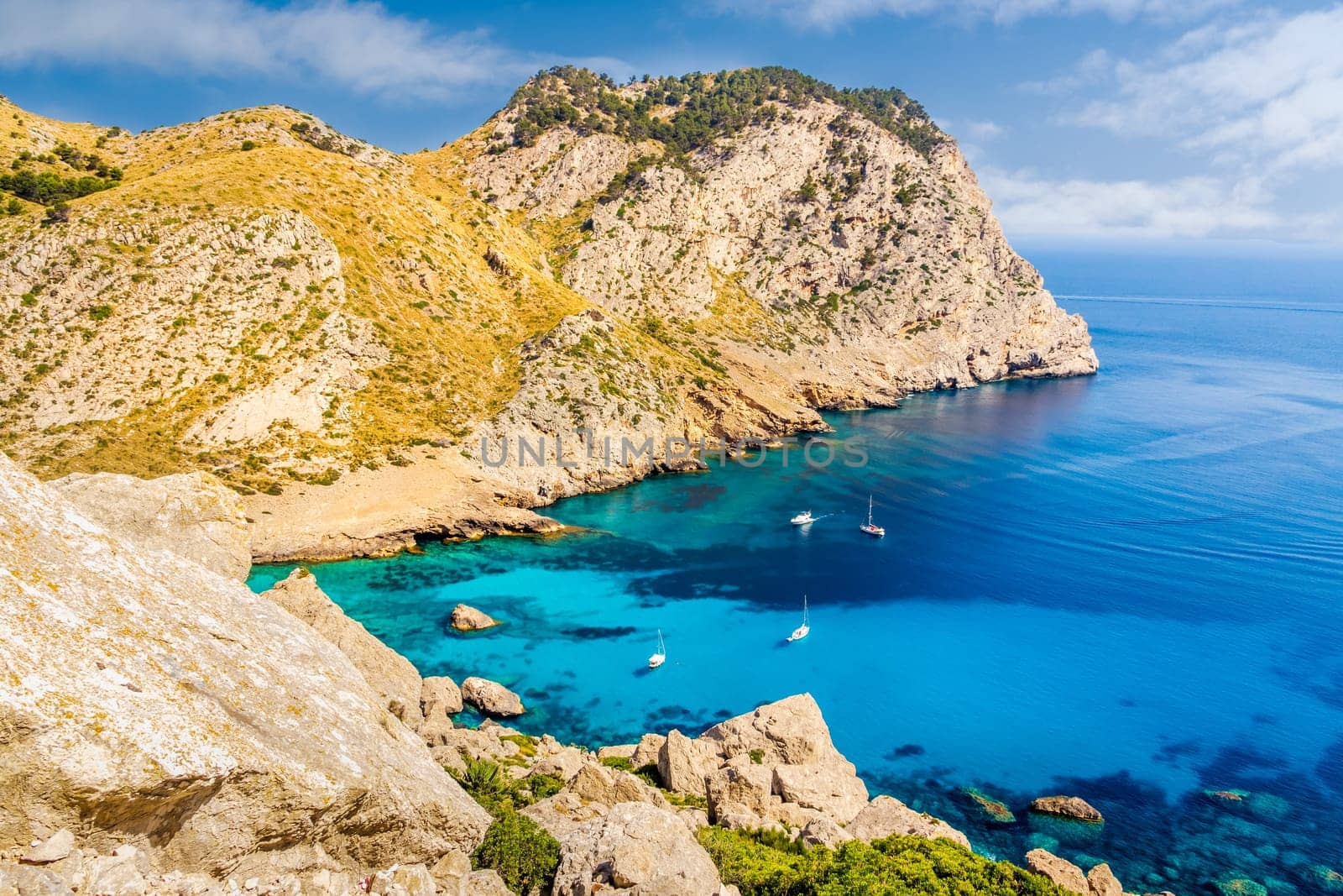 Beautiful coastline view of the cliffs with clear turquoise water and yachts. Cala Figuera beach on Cap de Formentor, Mallorca, Spain