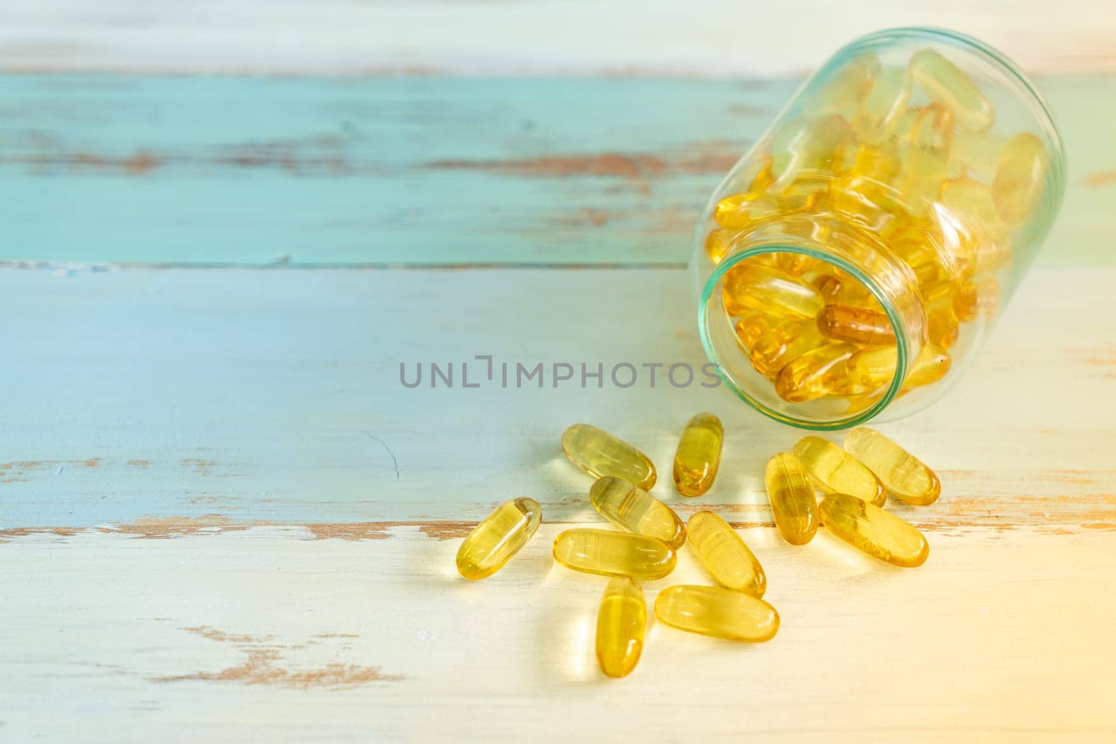 Pills medicine spilling out of pill bottle on vintage wooden background