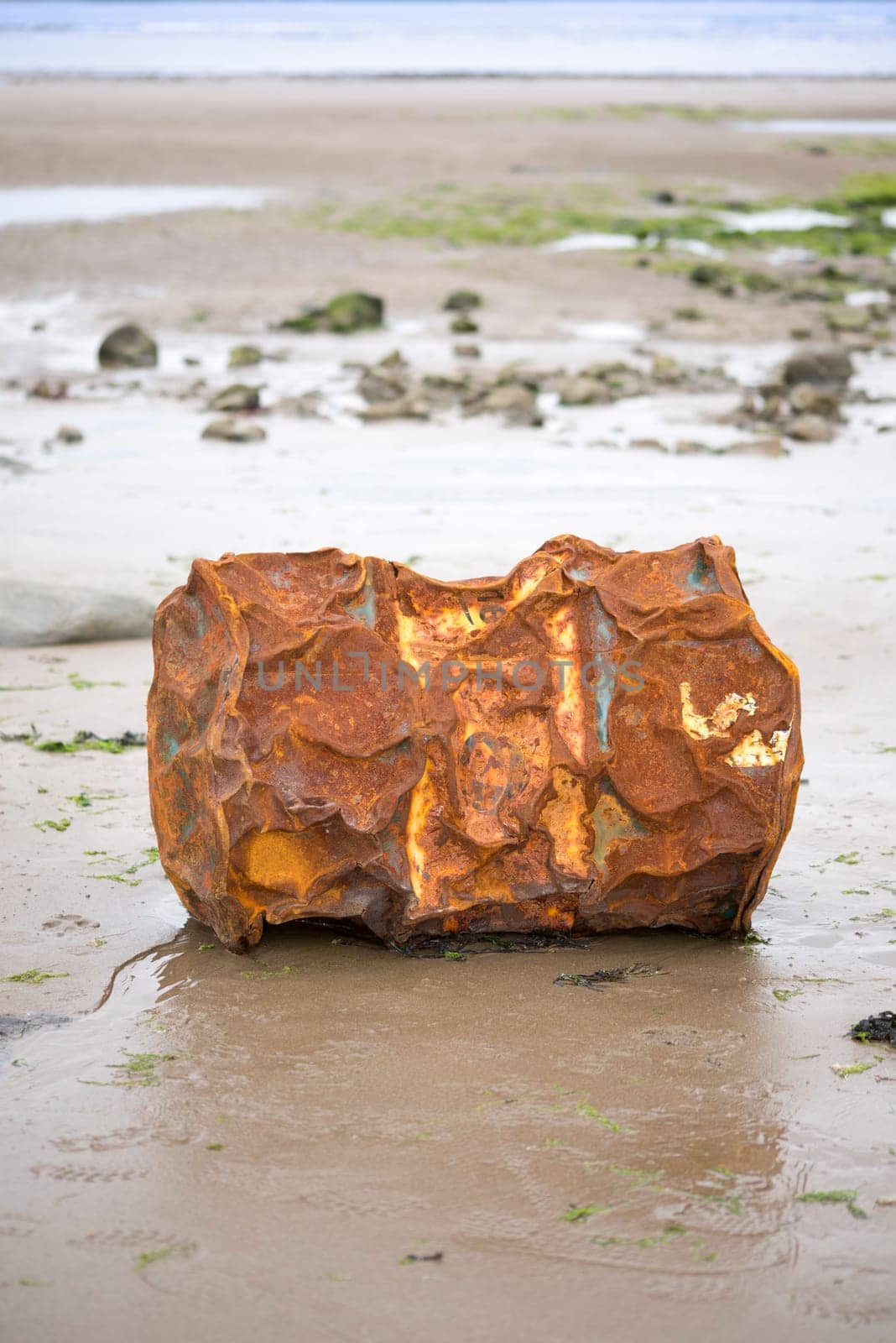rusty metal barrel washed up on the beach