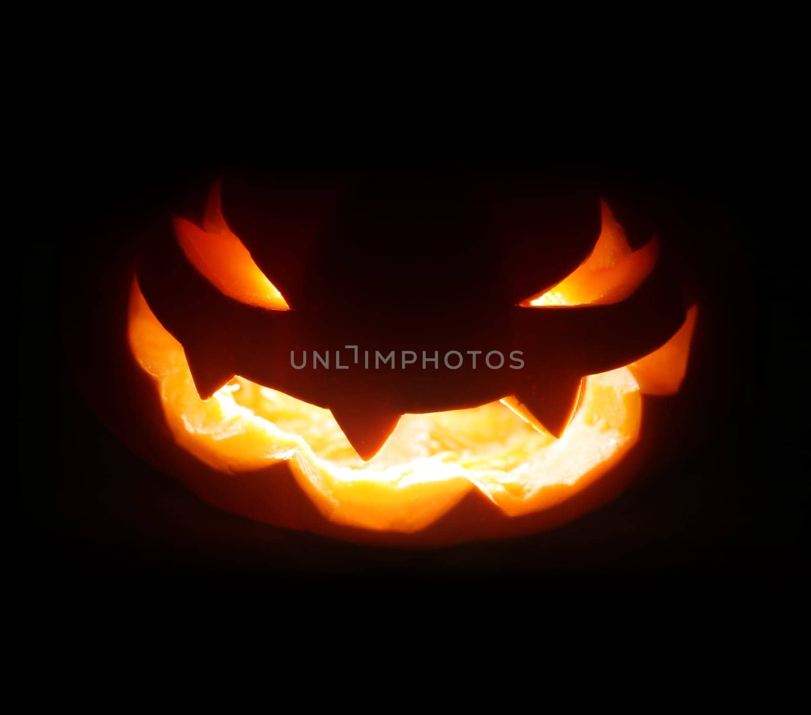 Spooky Halloween jack o lantern face glowing in the dark