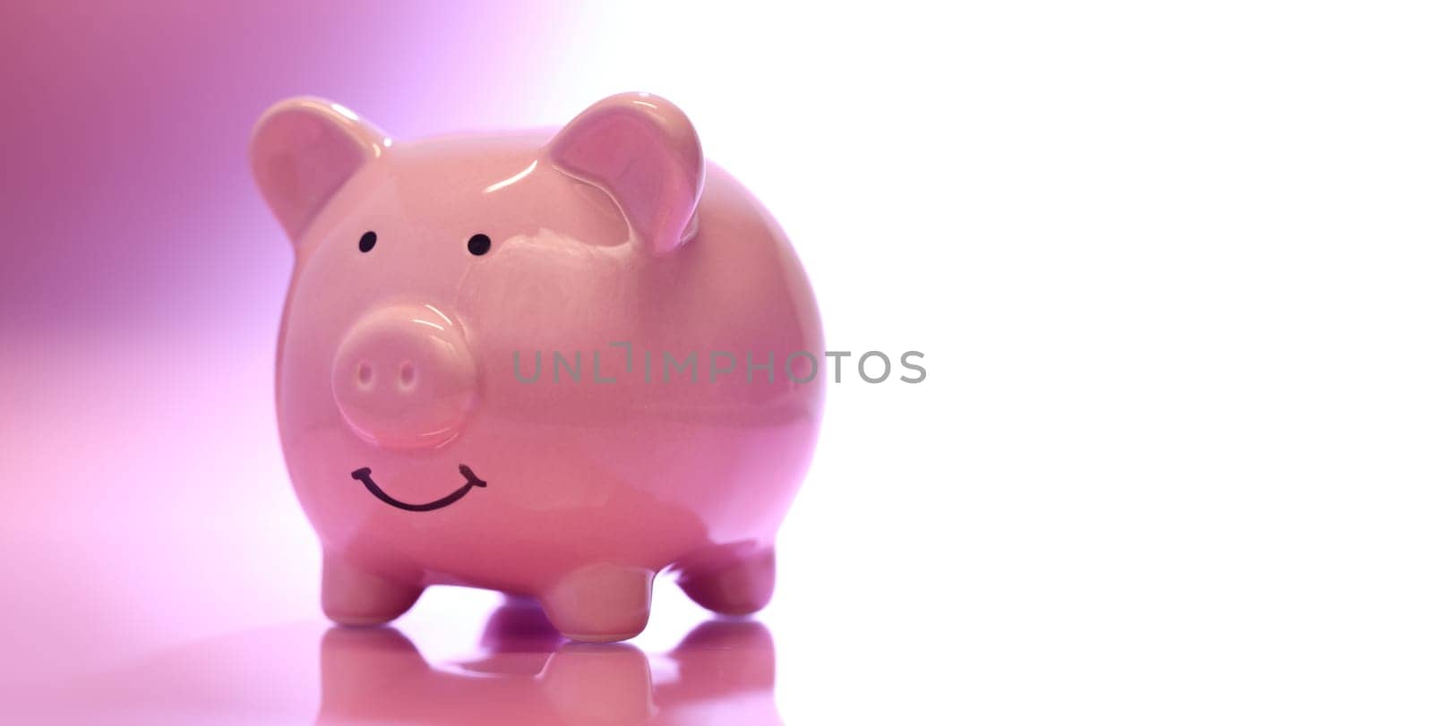Smiling Piggybank on pink background. Saving money concept.