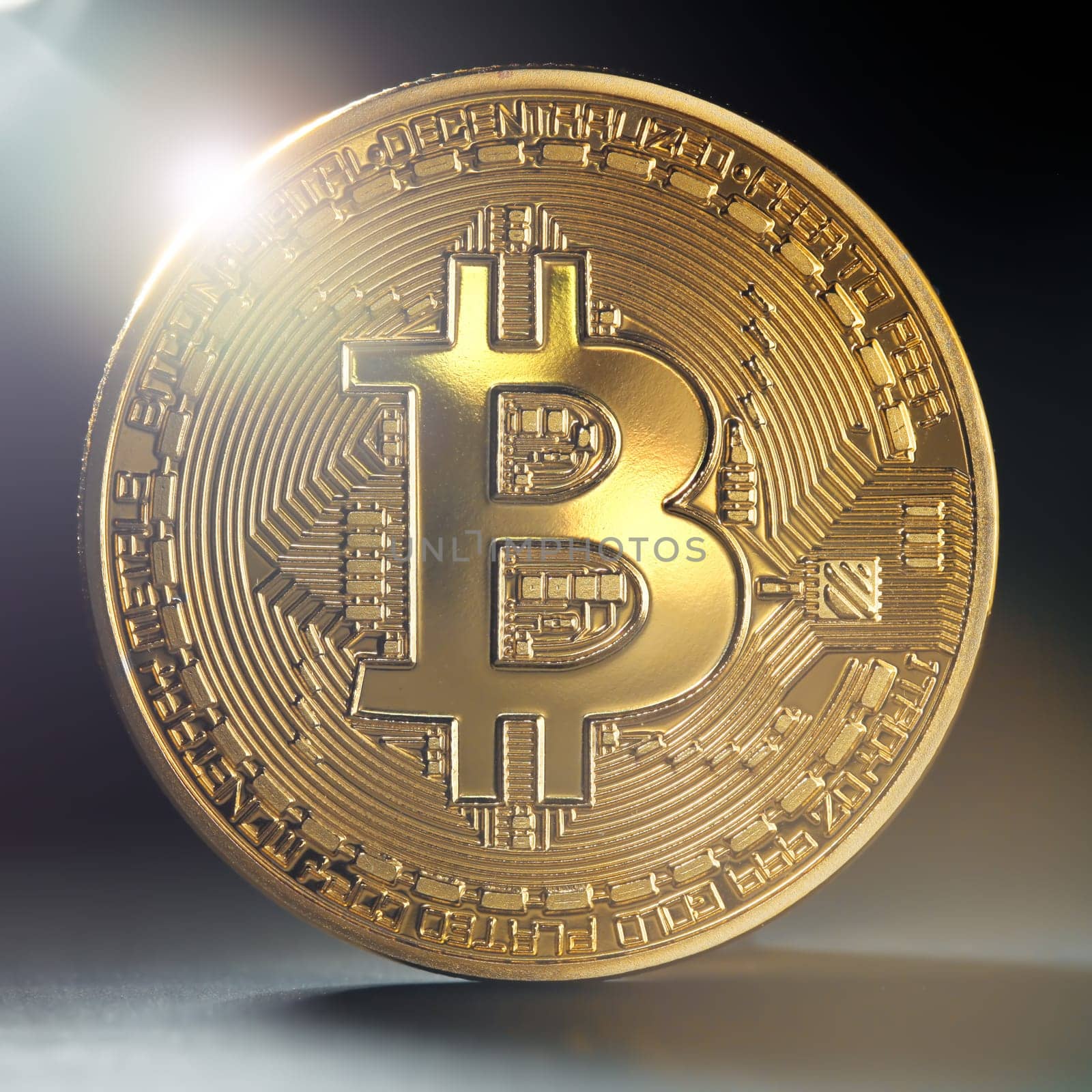 Close up of a single golden bitcoin coin in shining light.  Wealth, digital, virtual, currency, and cryptocurrency concept.