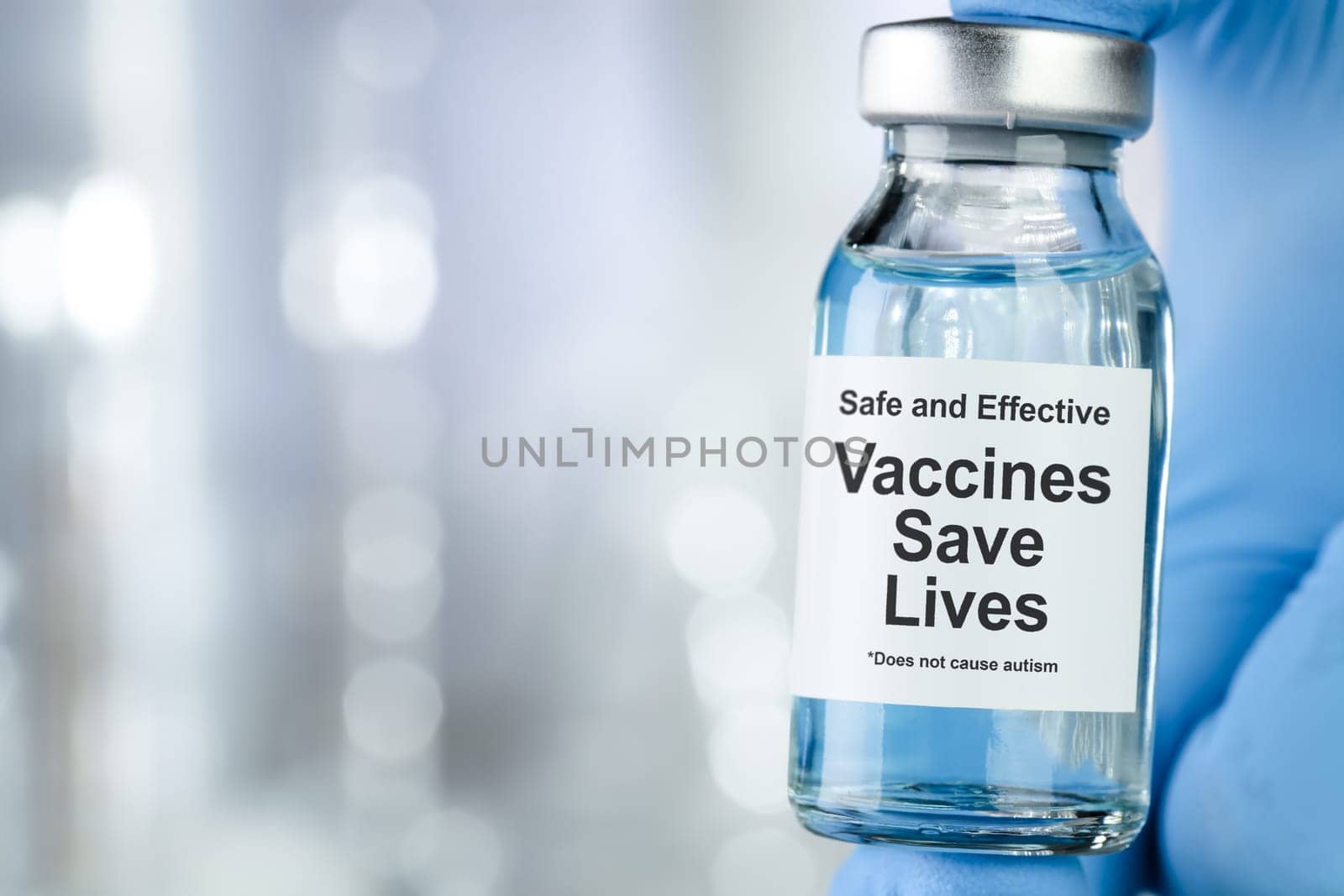 Healthcare concept with a hand in blue medical gloves holding a vaccine vial wtih the words Safe and Effective, Vaccines Save Lives, and does not cause autism
