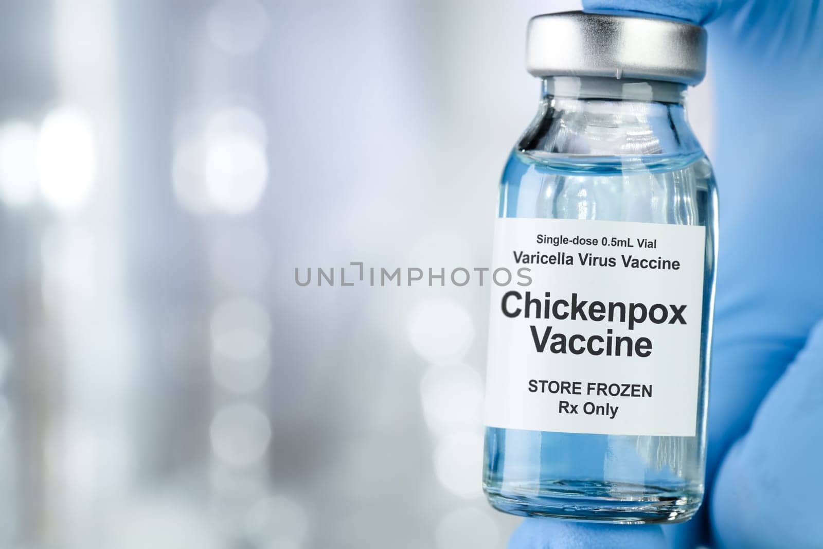 Healthcare concept with a hand in blue medical gloves holding Chicken pox, varicella-zoster virus, vaccine vial