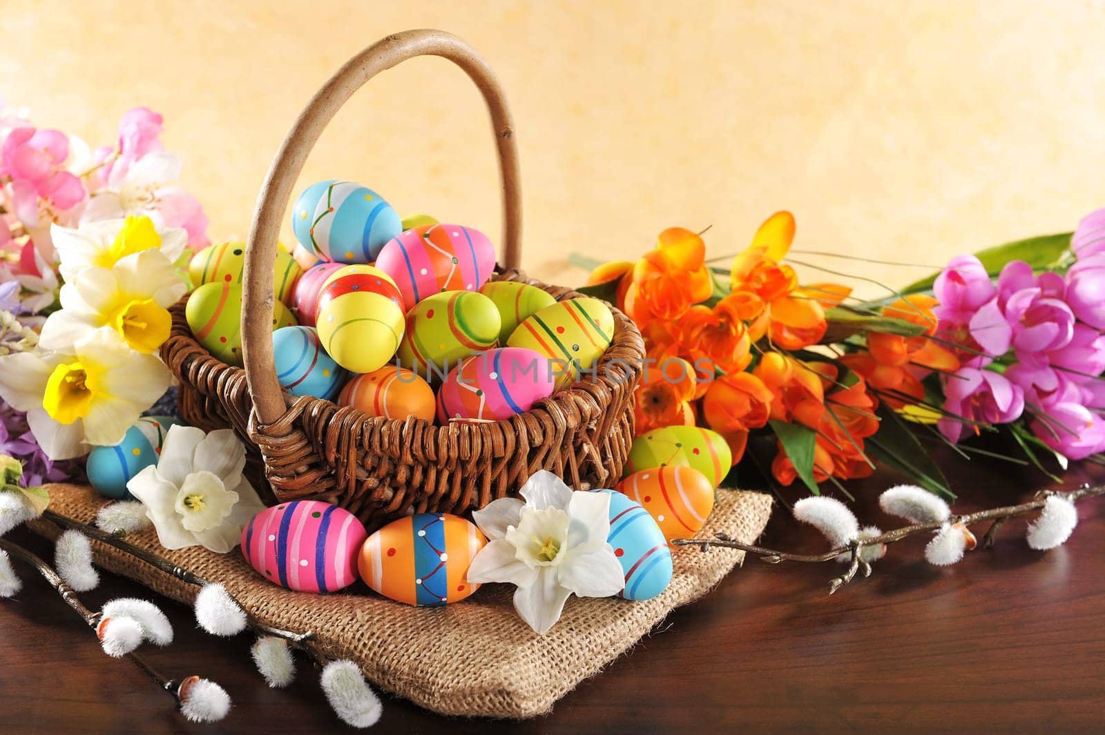 Easter nest with many painted Easter eggs,daffodils and palm kittens