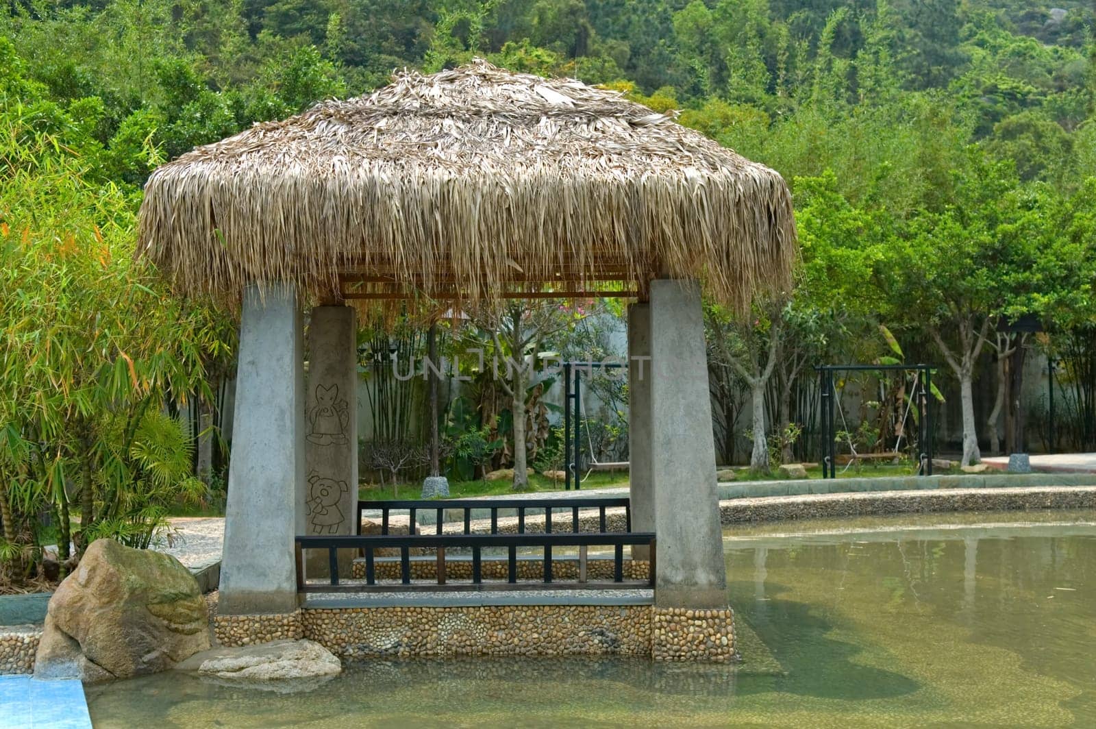 The pavilion with thatch roof beside swimming pool