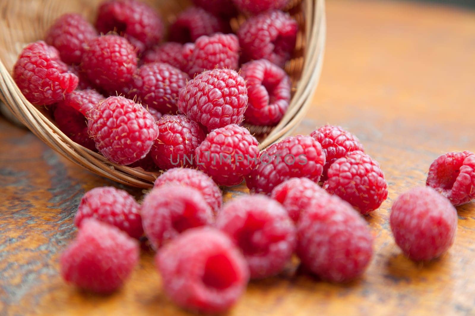 Fresh and tasty looking raspberries on a wooden table