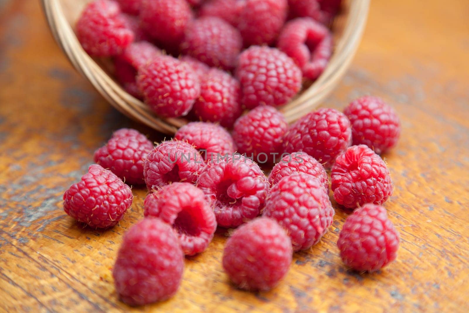 Fresh and tasty looking raspberries on a wooden table