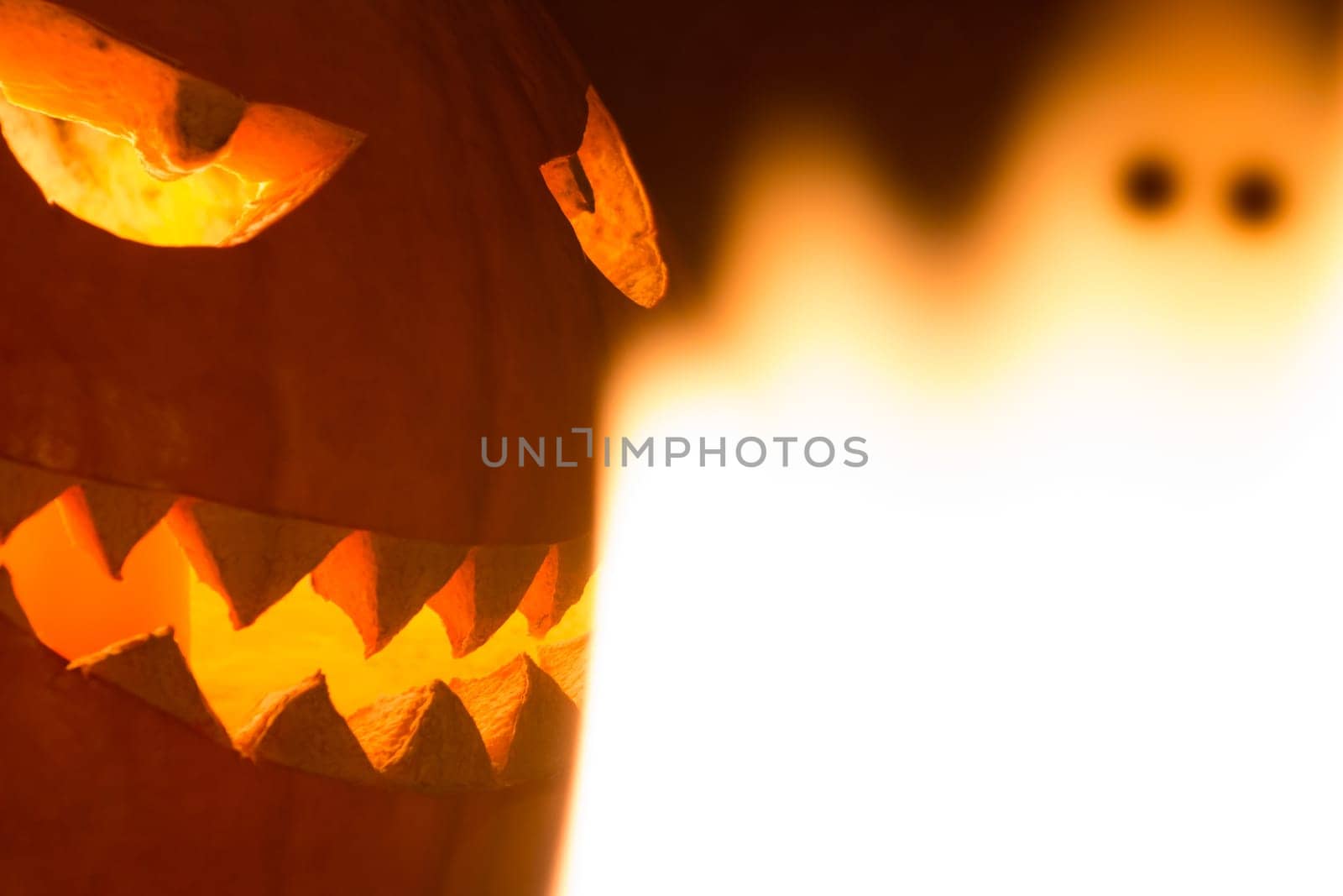 Big helloween autumn symbol with mad face, glowing eyes, mouth and teeth. Scary hot nightmare horror with evil smile at october 31st.