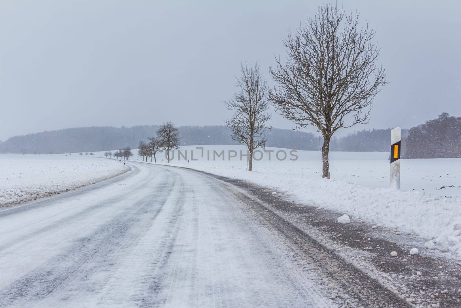 The street track is slick and frozen. High dangerous risk of an accident through the blizzard snowstorm and severe weather at christmas time season.
