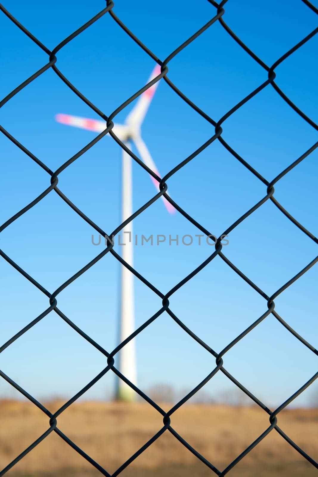 Wind turbine behind a fence in an industrial area in Magdeburg