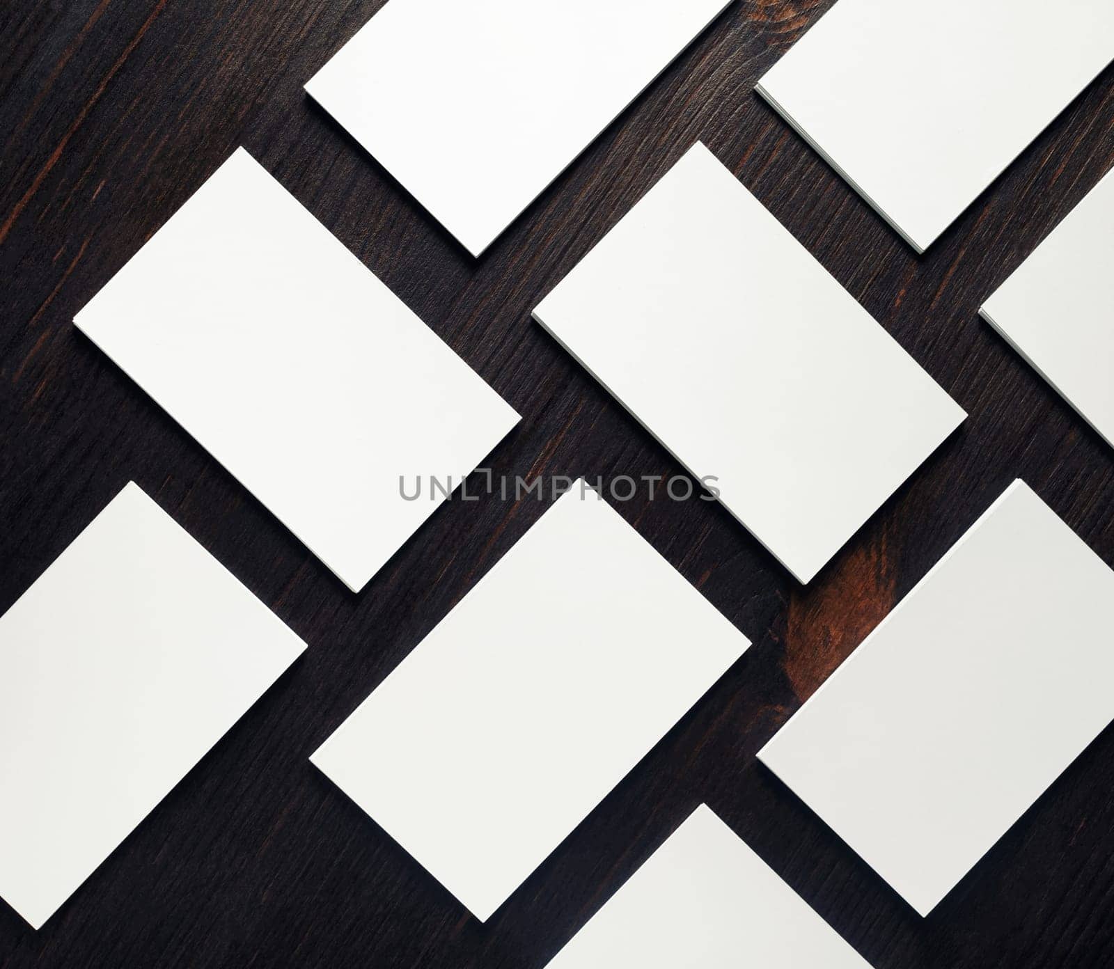 Blank white business cards on wood table background. Mockup for branding identity. Copy space for text. Flat lay.