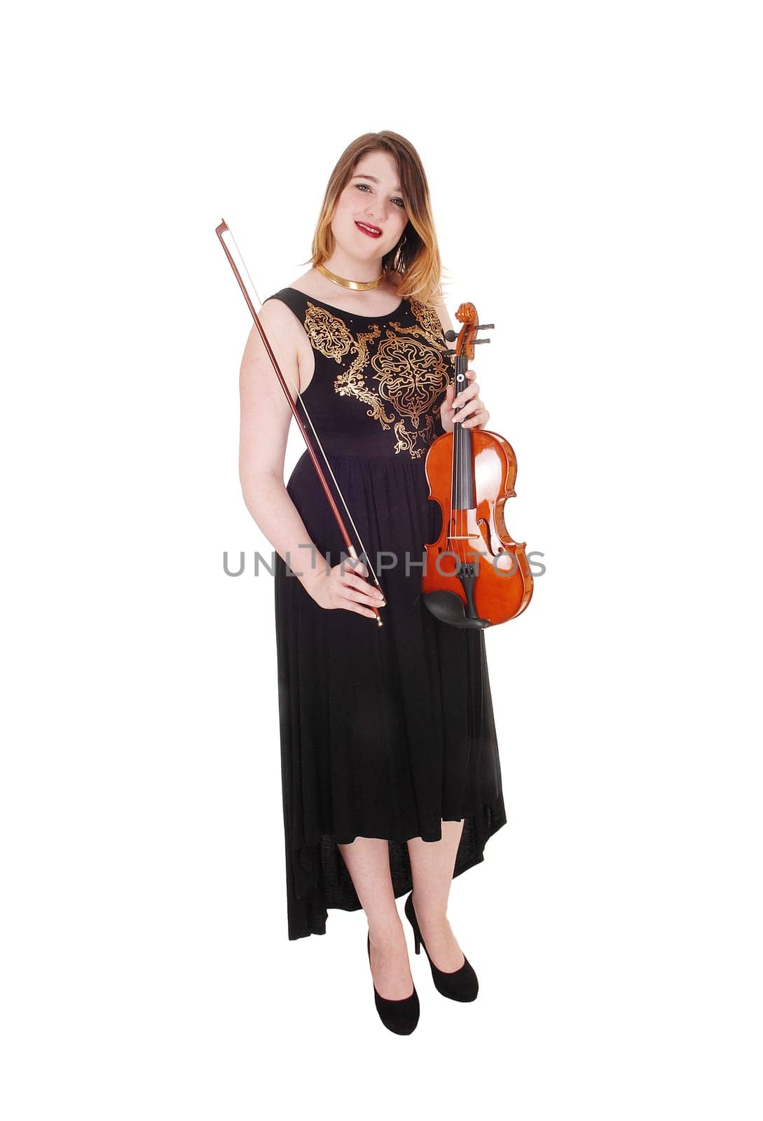 A beautiful woman standing in a long black dress in the studio, holding.her violin and smiling, isolated for white background.