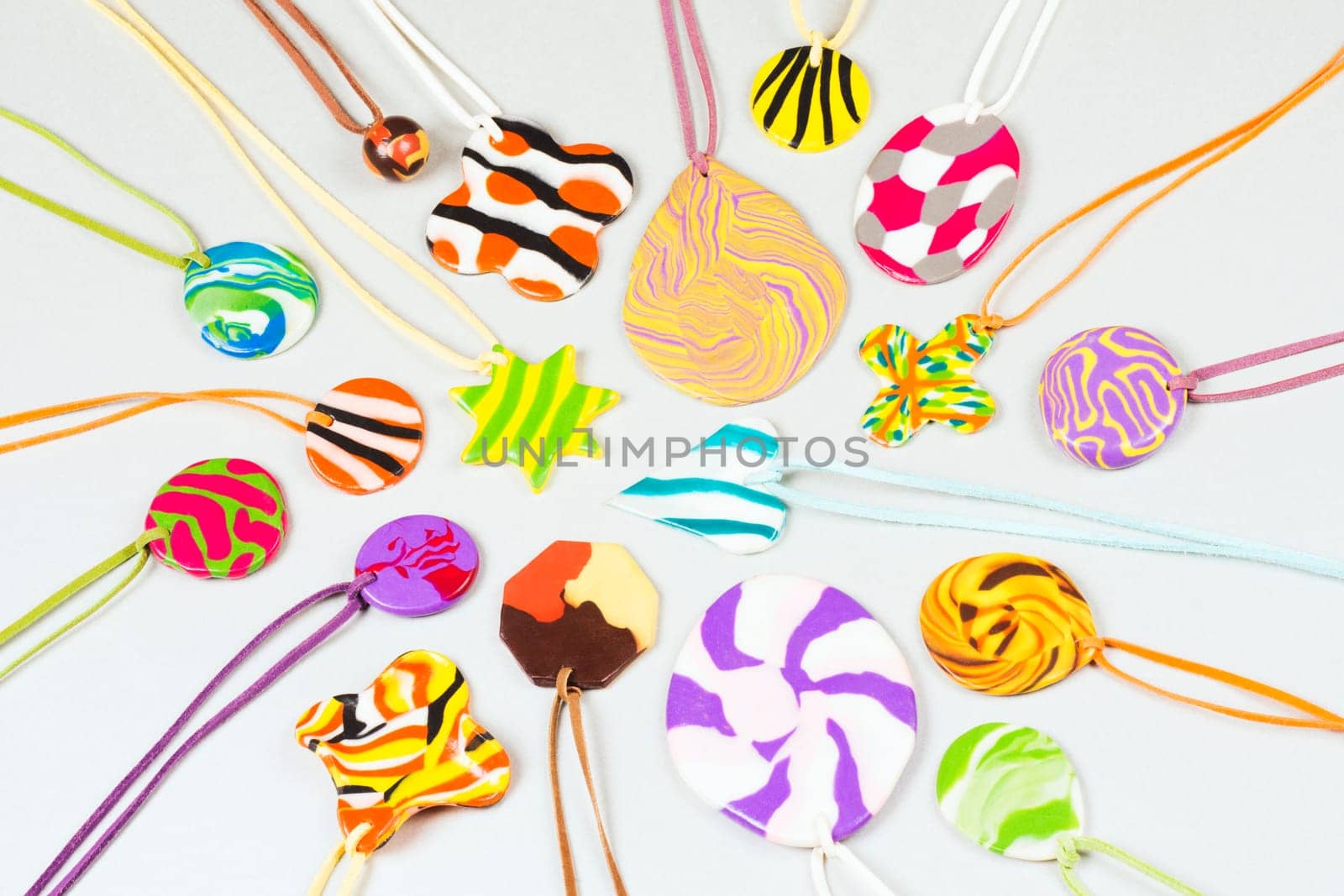 Colorful handmade trinket from clay for children on light gray background.