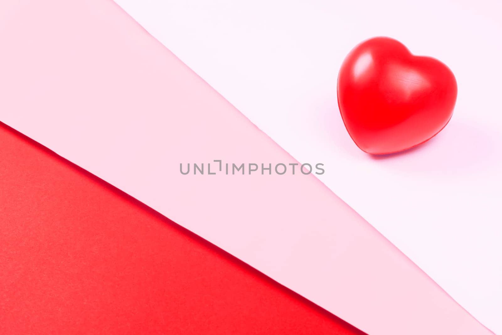 Abstract red heart on white, pink and red background, symbol of love, minimalism.