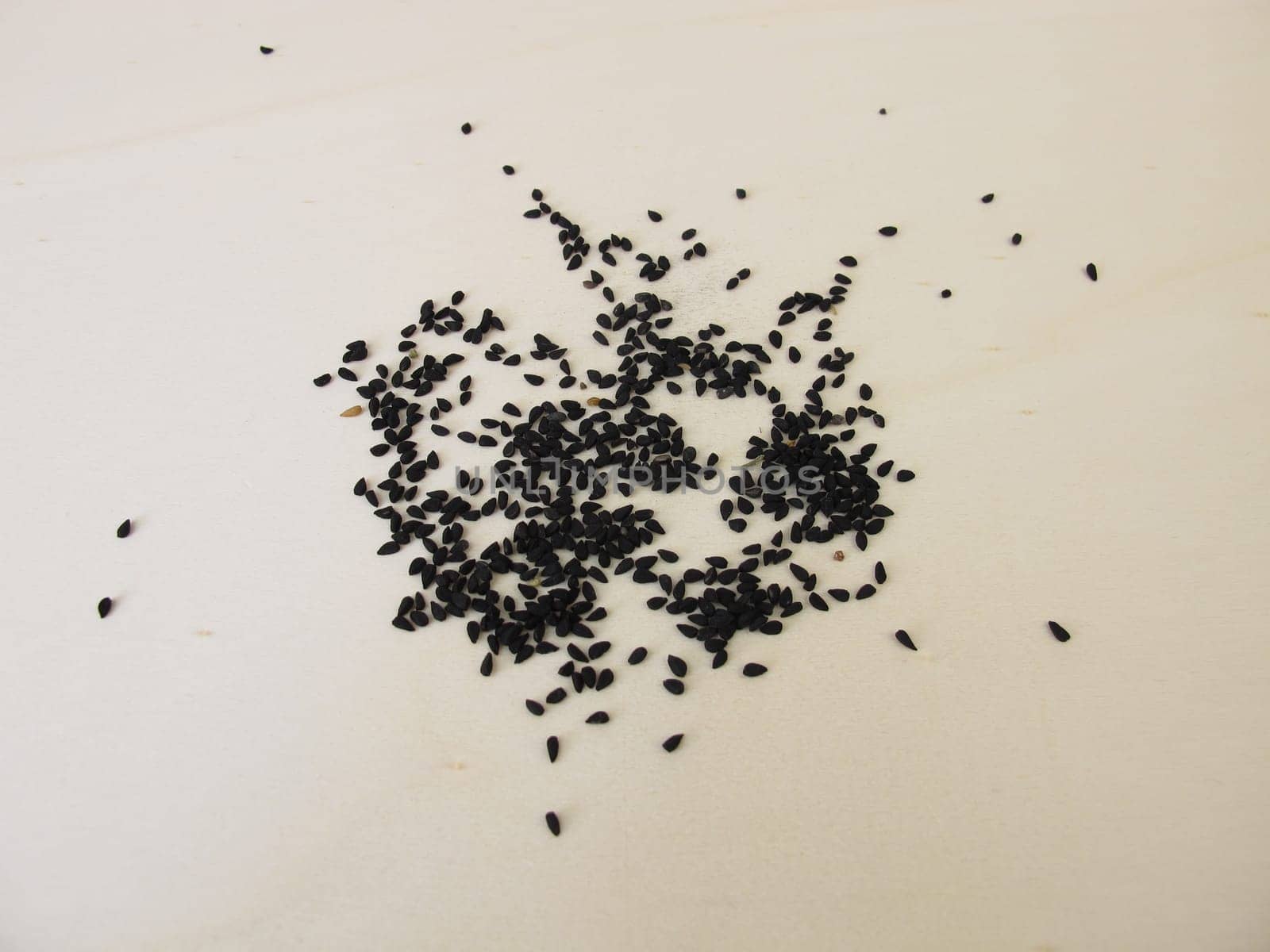 Black caraway seeds on a wooden board