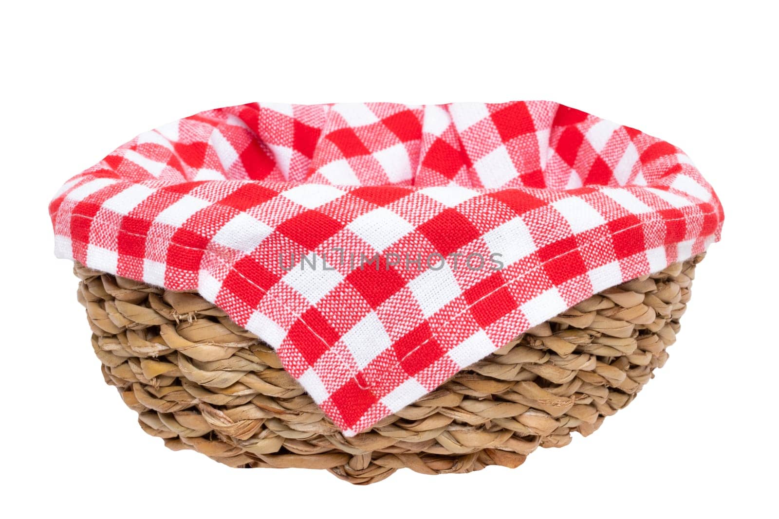 Empty picnic basket. Close-up of a empty straw basket therein a red checkered napkin isolated on a white background. For your food and product display montage. Macro.
