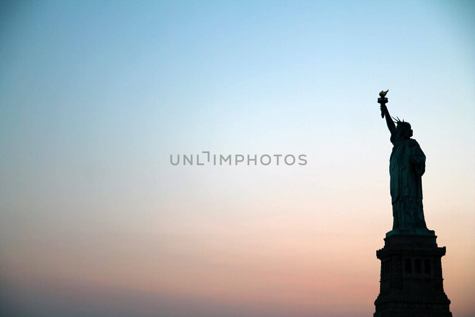 Sunset behind Statue of Liberty